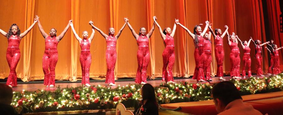 Students perform with the Rockettes on stage