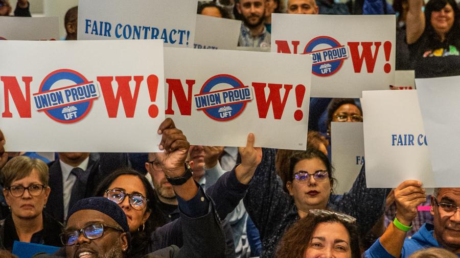 Members hold up signs in support of fair contracts
