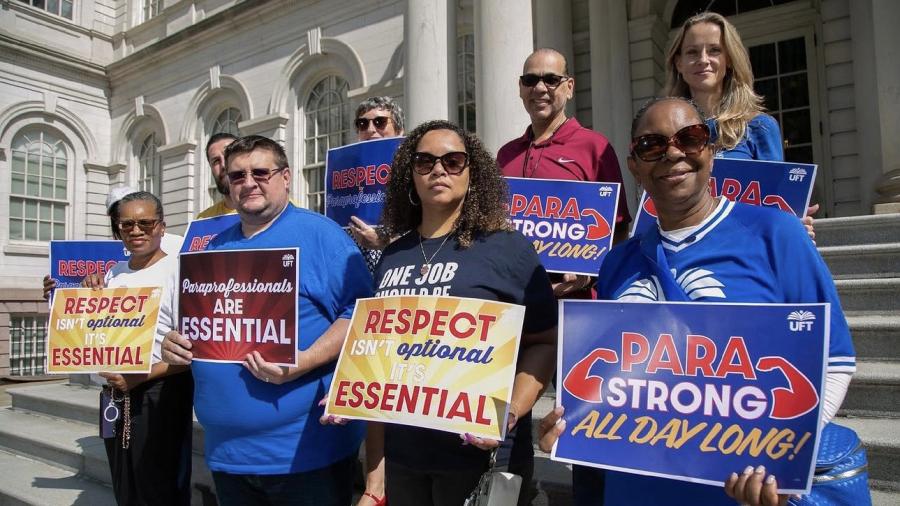 UFt members holding signs standing in front of NY City Hall