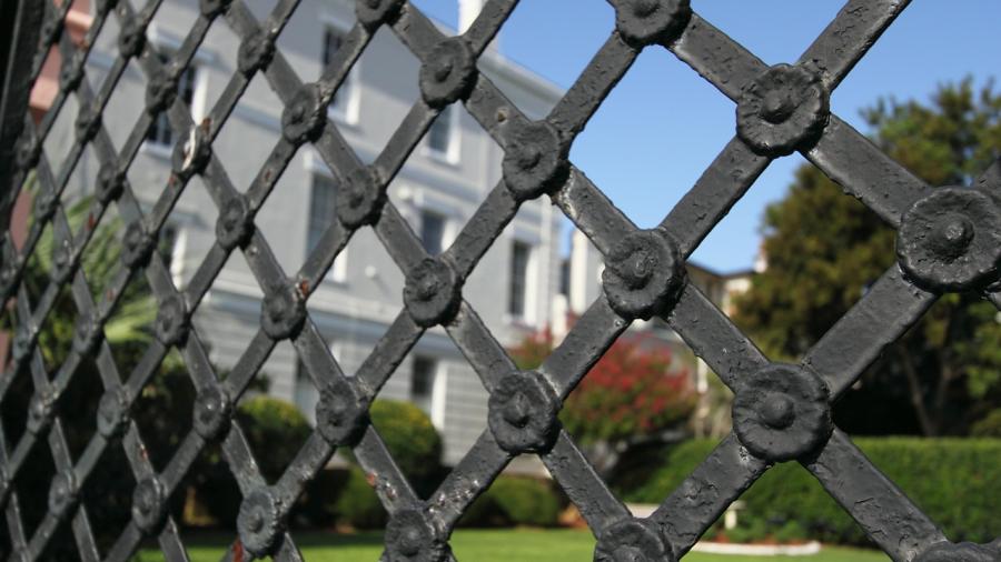 Iron gate with building in the background - Generic