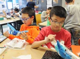 Fourth-graders add the finishing touches to their projects.