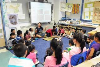 Teacher Angela Fremont (seated under whiteboard) leads a discussion about the ki
