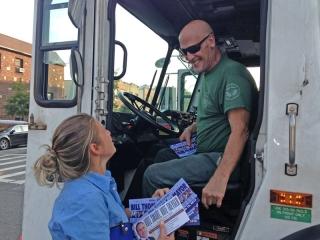 Theresa Cardazone hands literature to a city sanitation worker.