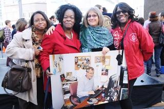 Streich (second from right), holding a photo of her husband in his office.