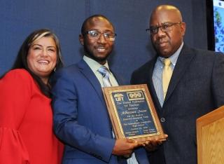 New York State Teacher of the Year Alhassan Susso is presented with a plaque by 