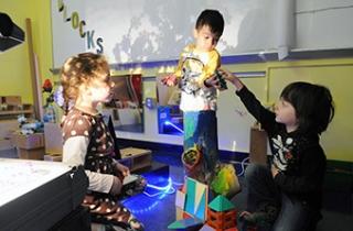 Students get creative in the block area, which features a projector for casting 