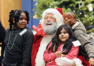 Santa shares a moment with children who are sporting some fabulous face paint.
