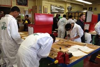 Visitors from the national CTE conference watch as students assemble a model of 