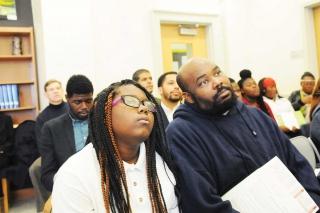 Markee Fullwood and his daughter Ashante, a 9th-grader, listen to the speakers.
