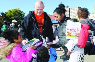 UFT President Michael Mulgrew helps Shanequa Oliver and her family pick out books. 