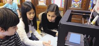 Class technician Emily (center) explains the 3D computer to the new tech team in