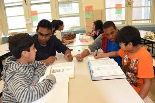 Mir Ahnak Hussain (back, left) and Charlie Ramirez work with their two students.