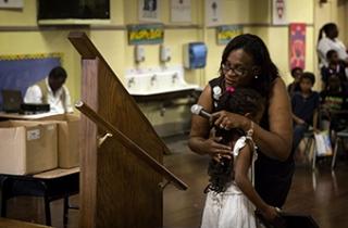 The principal at Alexander P. Tureaud Elementary School in New Orleans embraces a student at an end-of-year event. She won’t see the student next year since the school is closing. 