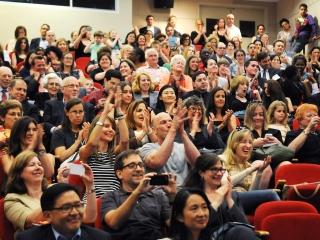 The standing-room-only crowd in the auditorium show their appreciation.