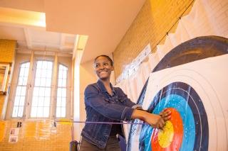 Eleventh-grader Liz Morency proudly pulls her bull's eye from the target.