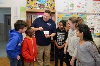 Teacher Bruce Gamsey goes over measuring the chemicals in the tank with some of 
