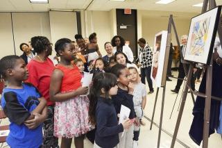Students and adults from PS 18 in Mott Haven admire the works of art.