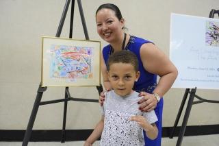  PS 18 art teacher Zoila Cordova and the artist stand by his work on display.