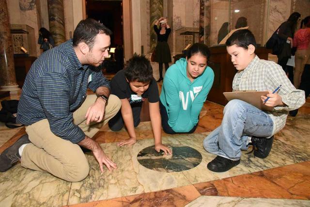 Students work alongside teacher Christopher Gianesses to study the pattern in th