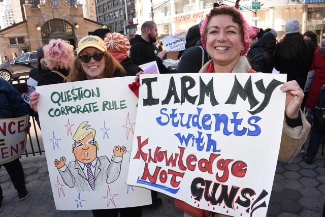 Karen Saunders (left) and Rytva Soni of the Bronx Collaborative MS hold up signs