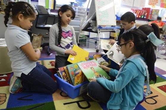 Second-graders at Washington Heights Academy check out books the school has received from First Book and the UFT through an Astor Foundation grant.