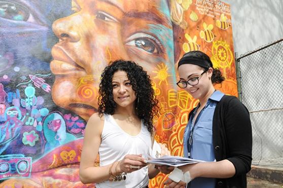 Two women in front of a mural