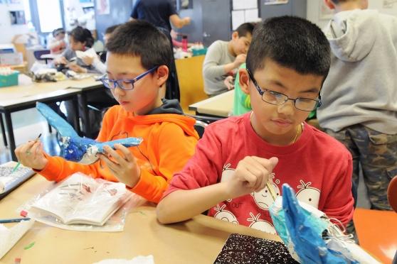 Fourth-graders add the finishing touches to their projects.