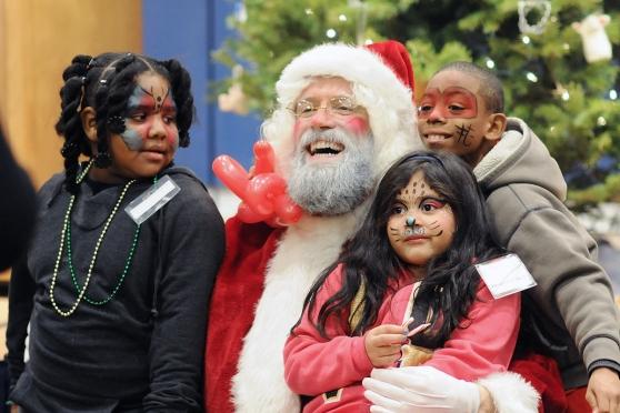 Santa shares a moment with children who are sporting some fabulous face paint.
