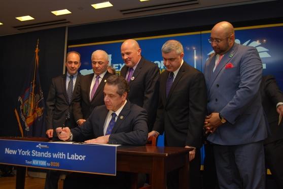 Gov. Cuomo, backed by labor leaders including UFT President Michael Mulgrew (cen