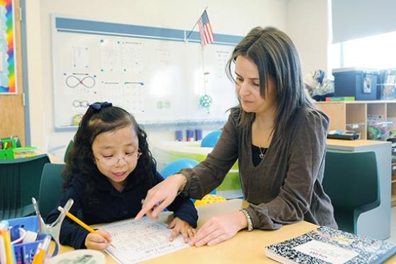 Occupational therapist Paige Tyson helps a kindergartner strengthen her pencil grip.