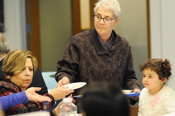Teacher Marci Pepper from PS 94 at PS 188 in District 75 serves gefilte fish to 