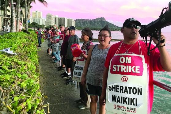 Striking hotel workers, who are members of UNITE HERE, picket on Oct. 18 on the 