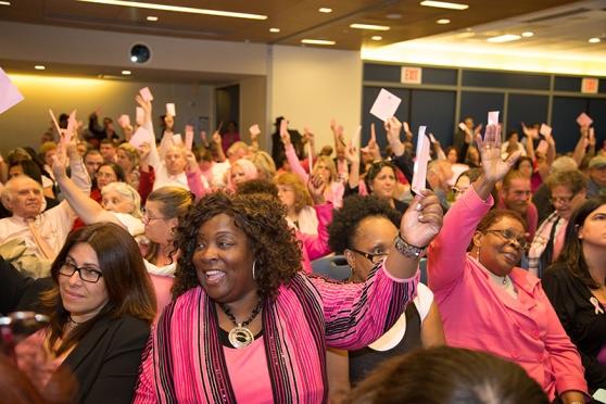 Delegates — many dressed in pink for breast cancer awareness — vote to approve.