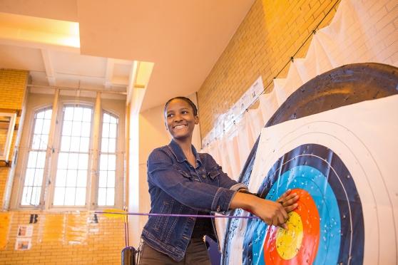 Eleventh-grader Liz Morency proudly pulls her bull's eye from the target.