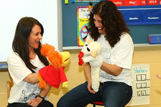 Michelle Sharabi and Hope Fogarty use puppets to teach kindergarten students about resolving conflicts. 