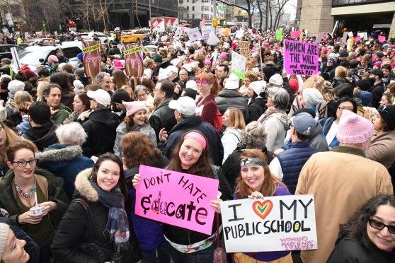 Holding signs in the New York City crowd are Jessica Horn (left) of PS 157 in th
