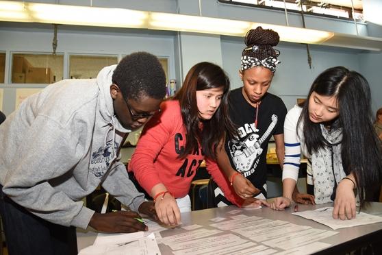Students at Emma Lazarus HS on the Lower East Side attempt to arrange strips of paper with single words or sentences into a coherent paragraph.