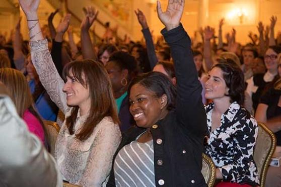 New fellows raise their hand in response to questions about where they came from