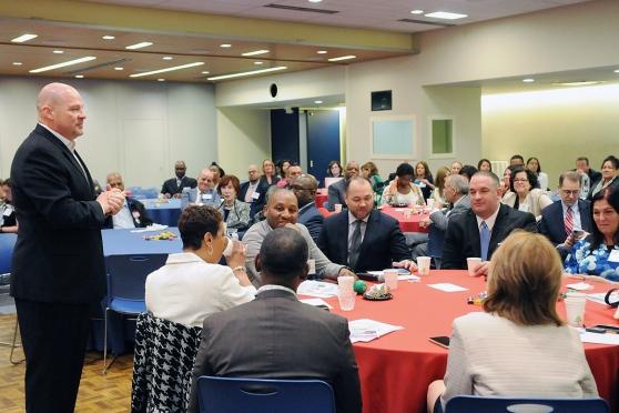 UFT President Michael Mulgrew standing in front of room full of people