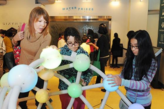 Teacher Jaimie Ellerbrock and some of her students make the math-music connection as they play on the Harmony of the Spheres, where each globe lights up in a different color and has a different tone or triad chord.