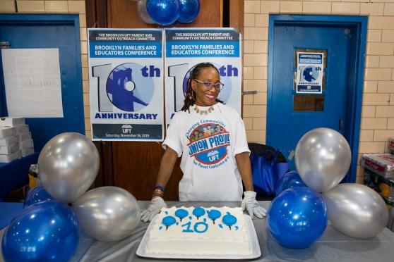 Karen Chambers, a parent volunteer for the Brooklyn conference, displays a 10th-anniversary cake.