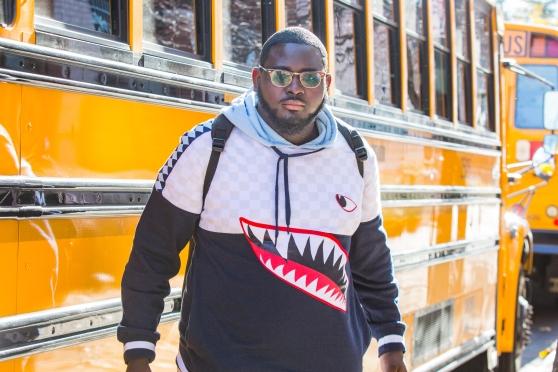 Man standing in front of yellow busses