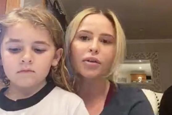 A screenshot of a nurse accepting an award, her son is also in the shot on the left side 