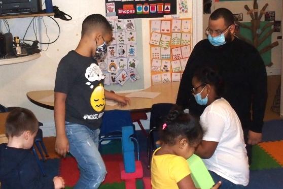 Students interact with a child care provider at a day care