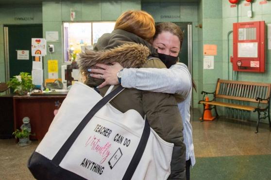 One teacher hugs another