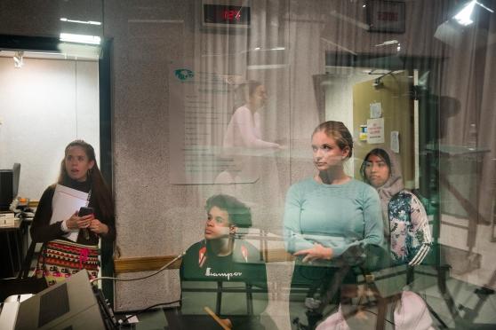 Teacher Ariana Cramer (right) is behind the glass in the control room with her students in the Environmental Media Studio.