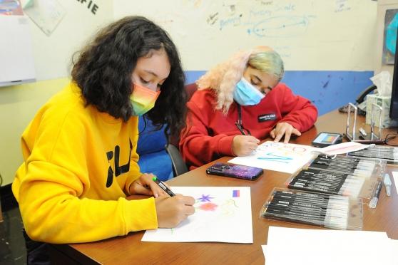 Students wearing using paintbrush pens