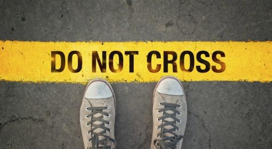 Sneakers touching a yellow do not cross line