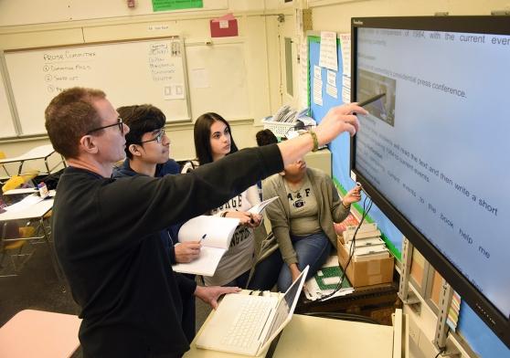 Green School HS Chapter Leader James Van Nort works with English students on an 