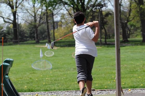A student steps into his swing on the driving range. • Mosholu golf coach John M